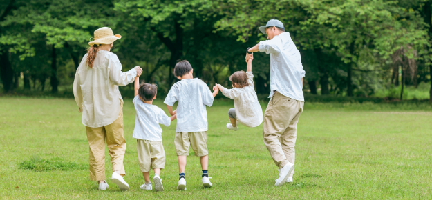 写真：芝生の上を歩く家族
