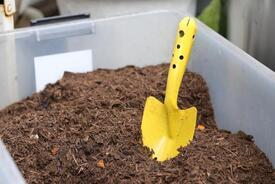 写真：衣装ケースに入ったたい肥の素とスコップ