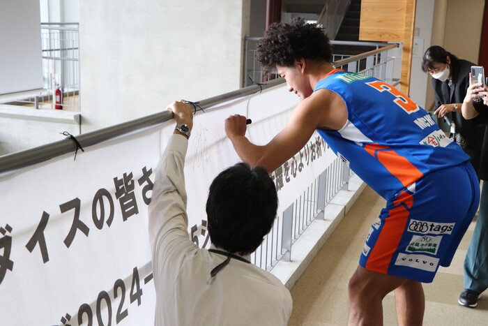 立川ダイスの選手に横断幕にサインをいただく様子