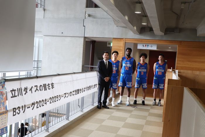 横断幕横に並び、集合写真を撮る立川ダイスの皆様