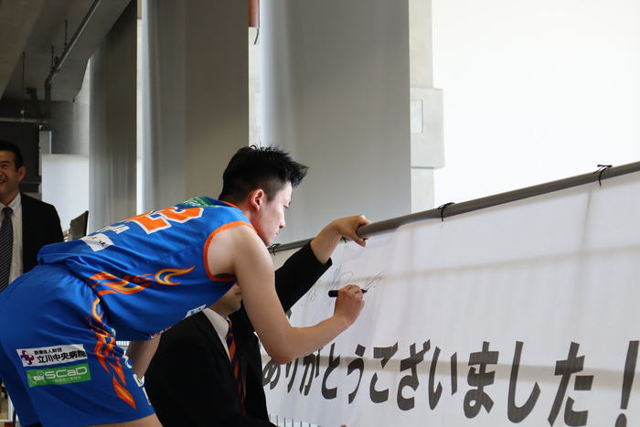 横断幕にサインを書いていただいている様子