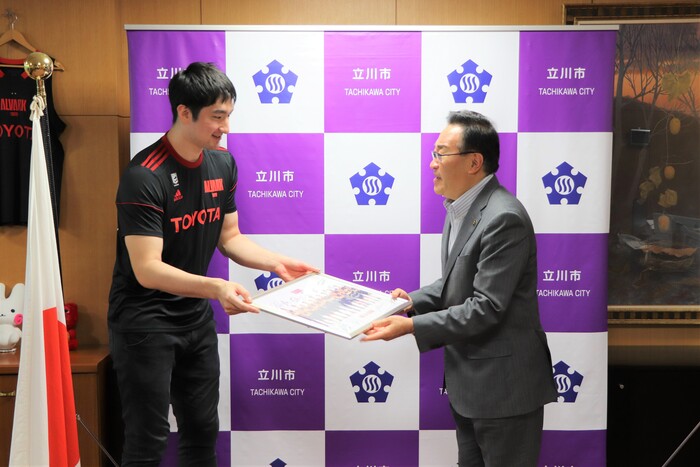 アルバルク東京の平岩選手にサイン入りの写真を酒井市長が受け取る様子