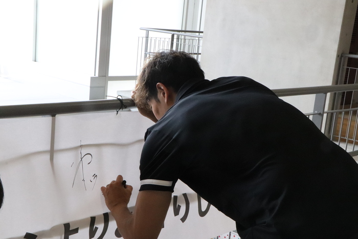 横断幕に直筆サインをいただいている様子