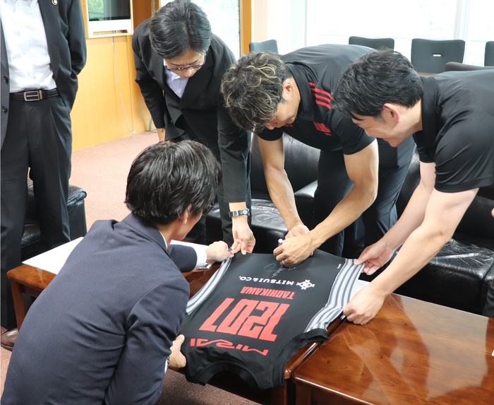 ユニフォームにサインする菊地選手