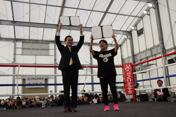 協定書を掲げる酒井市長と石川会長