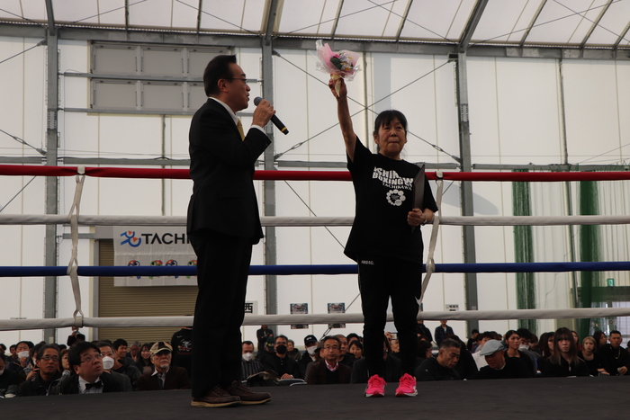 酒井市長から受け取った花束を掲げる石川会長