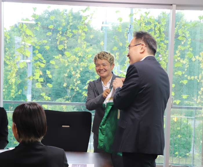 選手のサイン入りユニフォームを市長に渡す様子