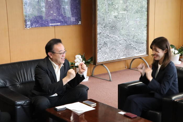 二人で向かい合い、ガッツポーズをする酒井市長と岡田選手