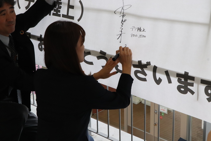 横断幕にサインを書く岡田選手