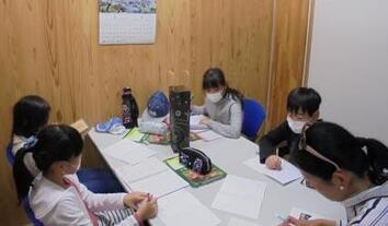 写真：メッセージカードを牛乳パックの再利用で作成している様子