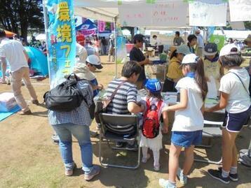 写真：植木のパンフレットを来場者に配ってる様子