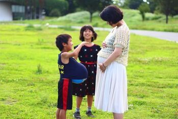 写真：妊娠している女性と男の子と女の子