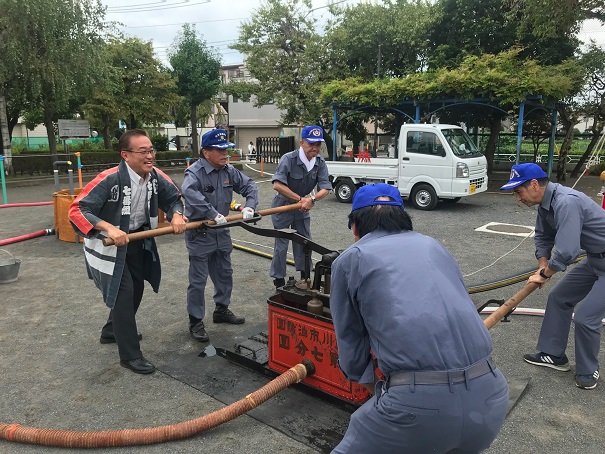 写真：七番組市民消火隊による手押ポンプ操法の様子
