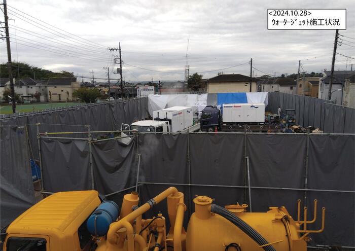 （仮称）砂川学習館・地域コミュニティ機能複合施設の工事現場です。防音シートの囲いの中に専門の車両が入って作業しています。