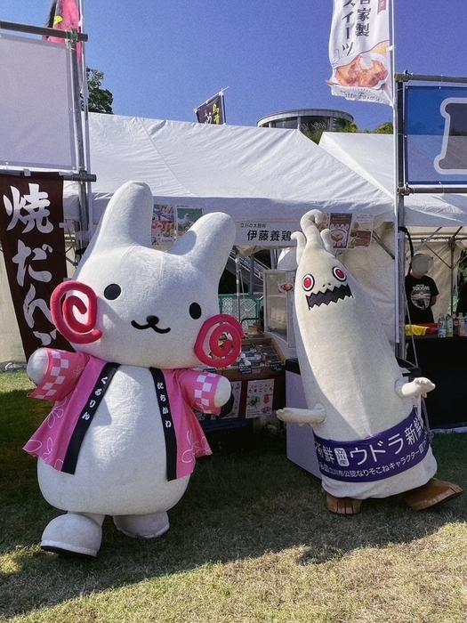 市内のお店の前でウドラと記念撮影をするくるりん