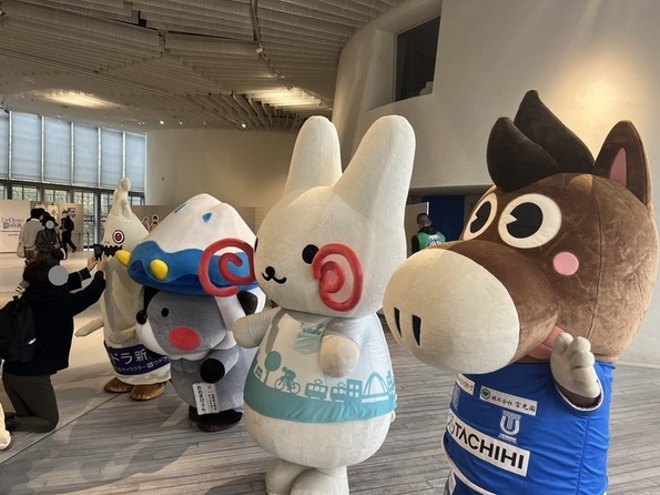 お客さんの前で立川市で活躍するキャラクターたちとポーズをとっているくるりん