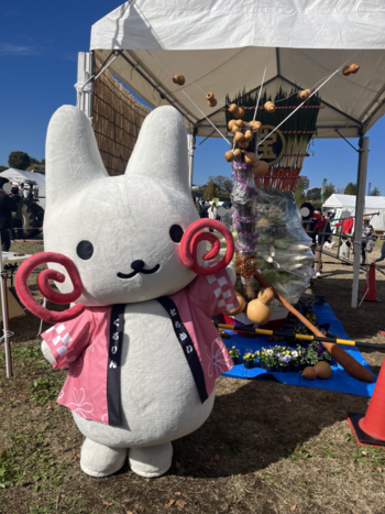 宝船の前でポーズをとるくるりん