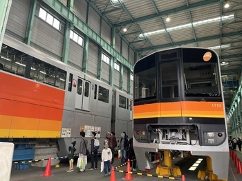 多摩モノレールの車両を見る人々。