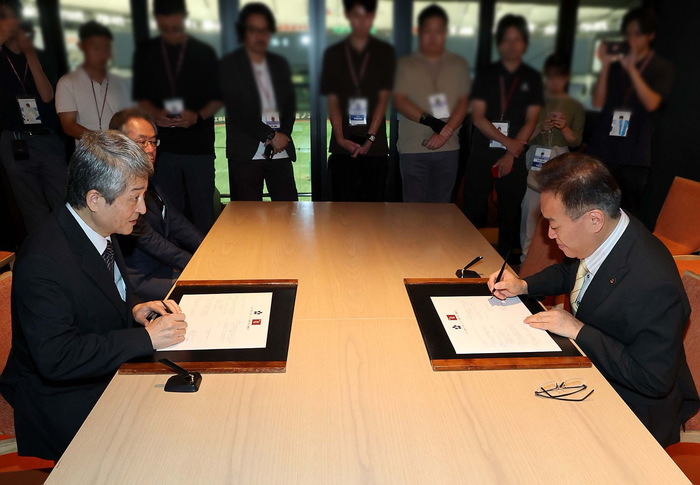読売巨人軍との連携協定締結式で署名する様子
