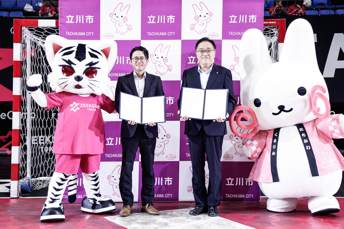 黒田真一社長と市長とマスコットの集合写真（左からジスター、黒田真一社長、市長、くるりん）