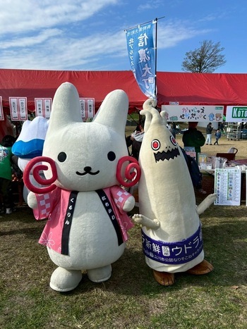 出店ブースの前で写真をとるくるりんとウドラ